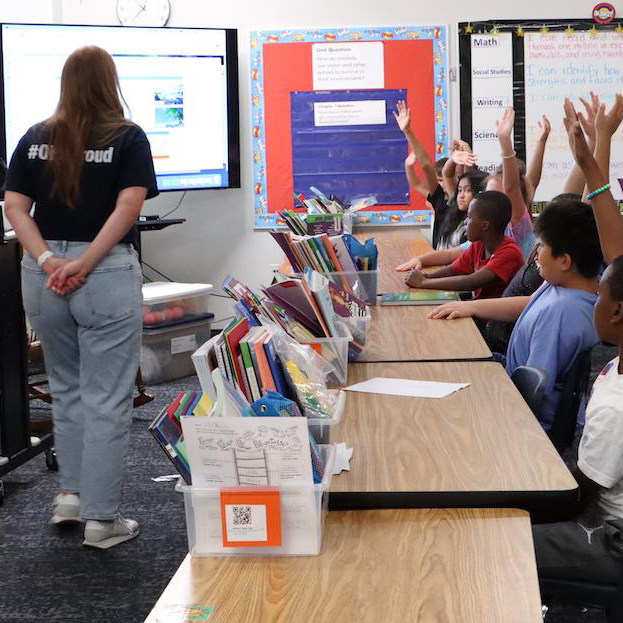  Students raise their hand to respond to a question